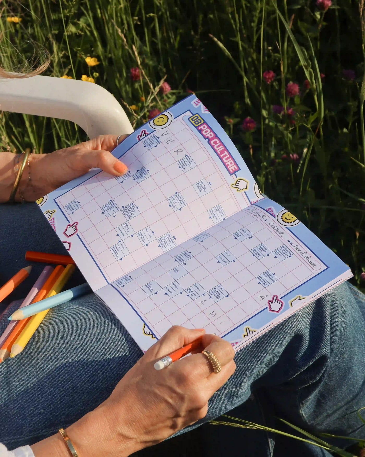 Cahier mots fléchés Grillé CULTURE bleu avec grilles remplies et crayons de couleur en extérieur au soleil