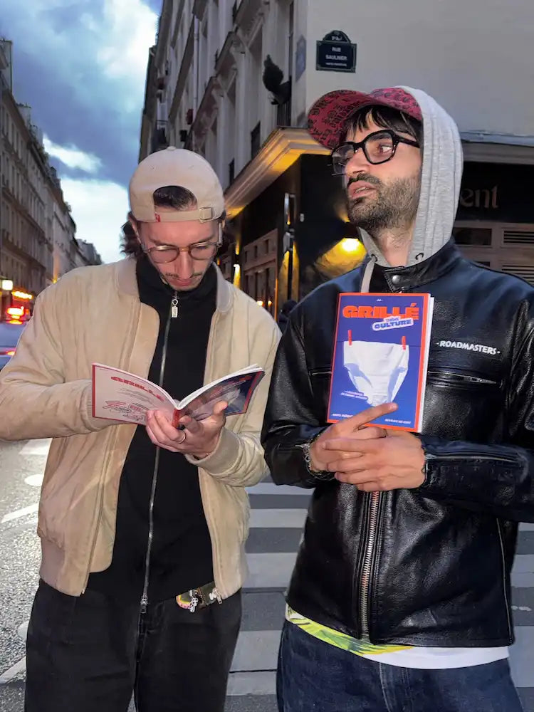 Deux jeunes hommes dans la rue tenant des cahiers Grillé culture, mots fléchés nouvelle génération