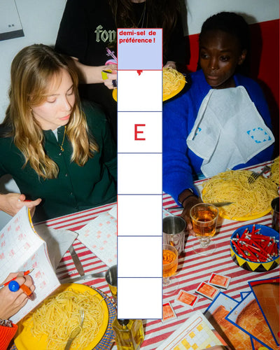 Amies partageant un dîner avec cahiers mots fléchés Grillé