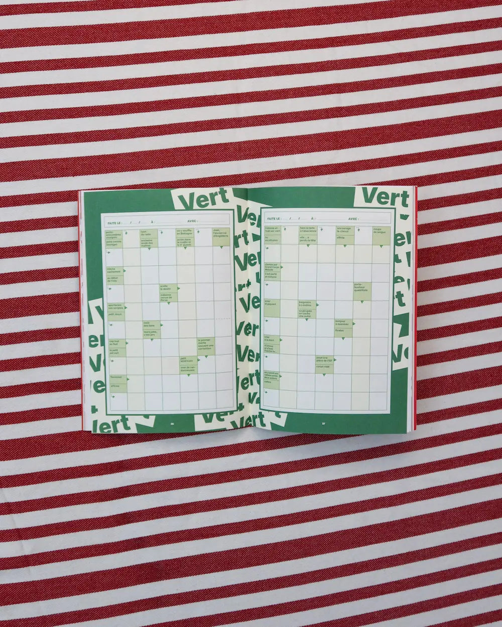 cahier mots fléchés ouvert sur une nappe rouge à rayures
