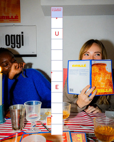 Amies partageant un dîner avec cahiers mots fléchés Grillé
